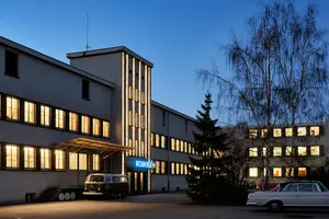 Beleuchteter Robugen Hinterhof bei Nacht mit Autos auf dem Hof